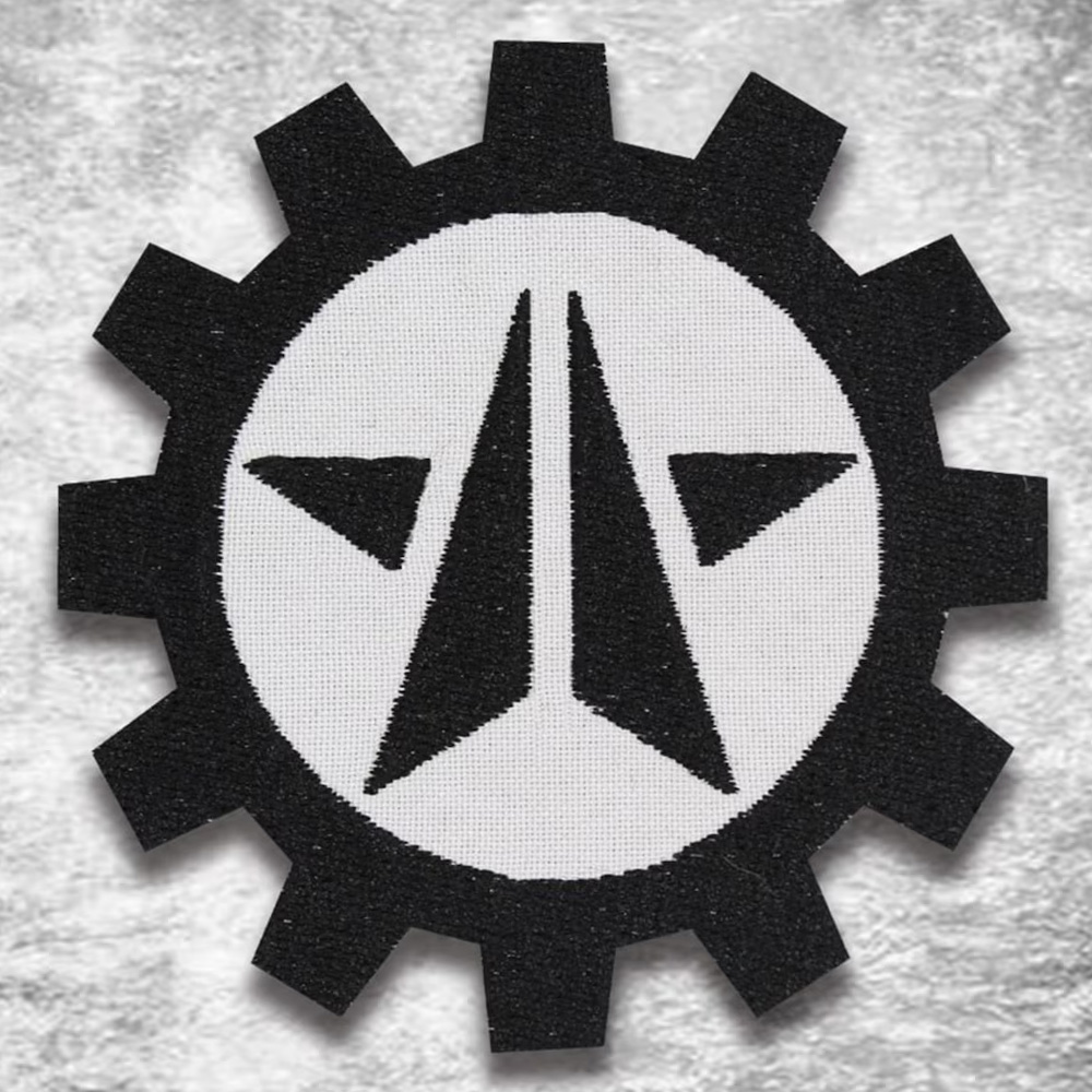 Embroidered patch of Helldivers emblem featuring a white arrowhead in a black gear